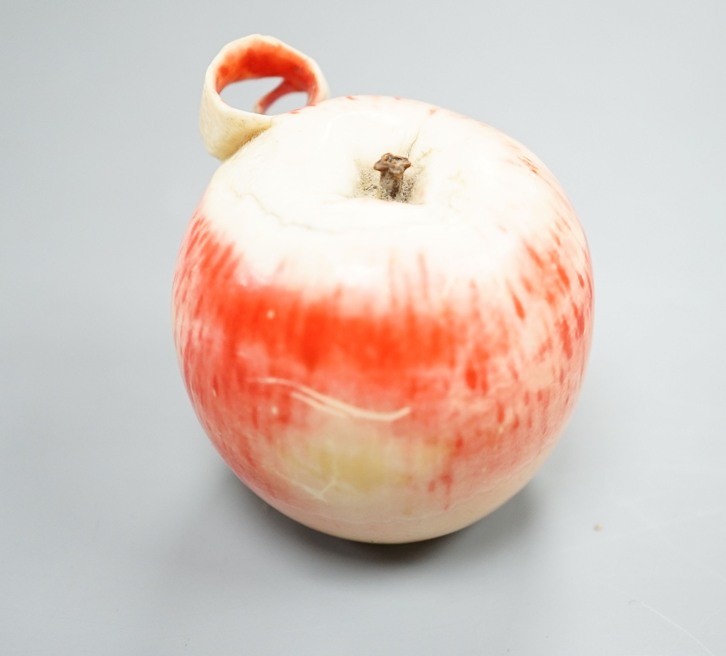 A Japanese carved ivory model of a partially peeled apple, c.1900, 5cm